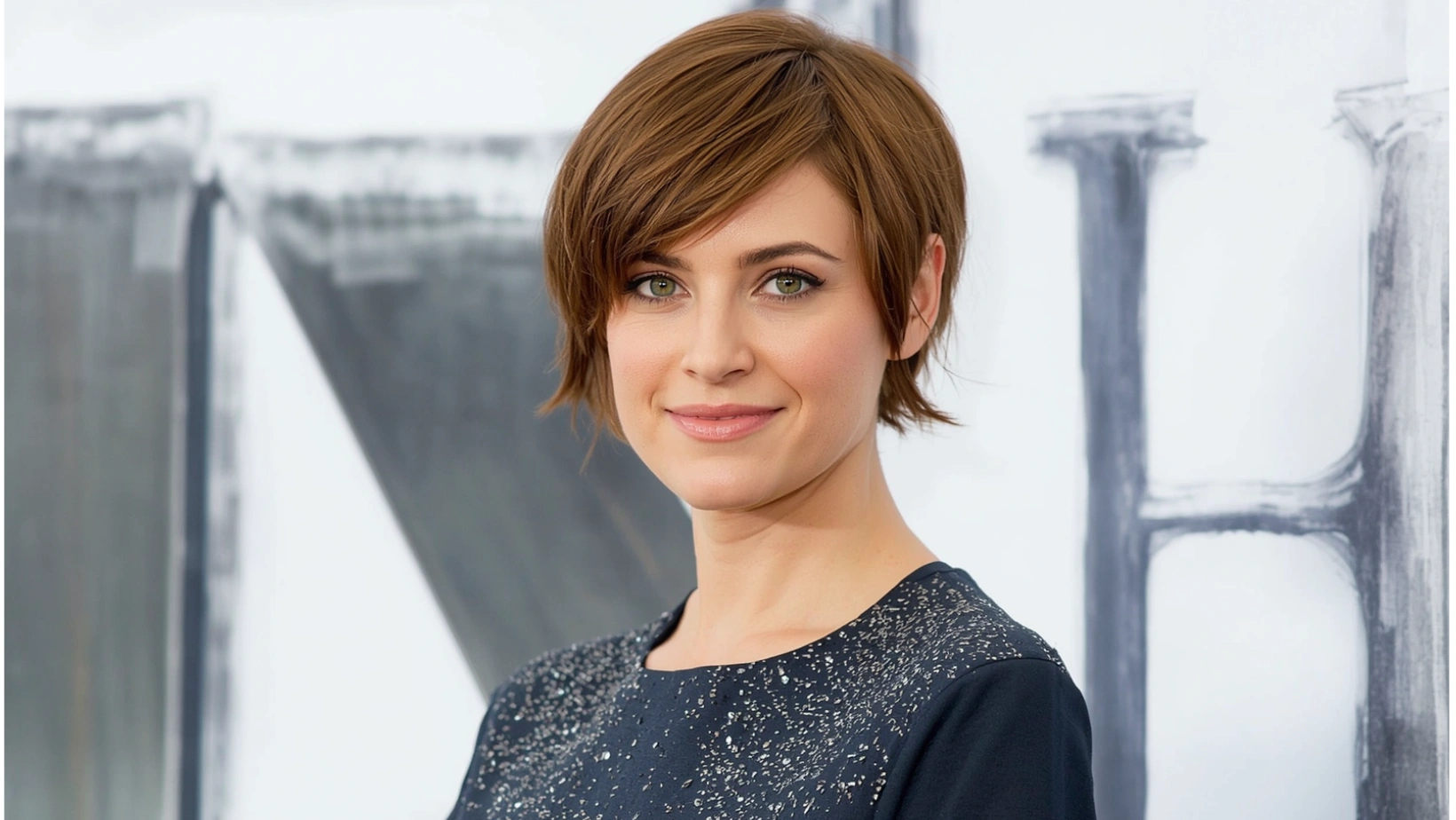 Woman with a textured pixie haircut and soft curtain bangs, example of modern pixie haircut ideas